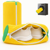 Load image into Gallery viewer, Yellow travel shoe bag with green accents containing white shoes, next to a black suitcase handle.